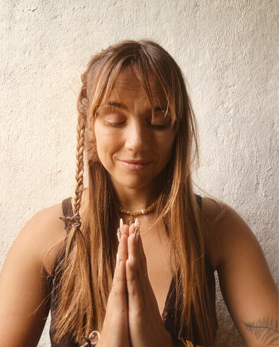 Michelle with braided hair and hands in namaste